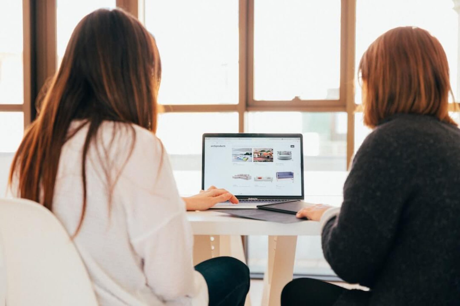 Photo de deux femmes travaillant sur un projet de création de site Internet